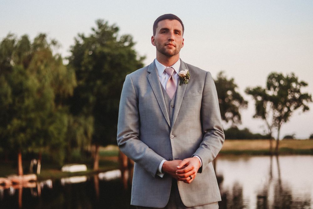 Elegant wedding portraits taken at sunset near a waterfront location.