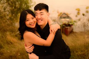 Couple embraces lovingly in a golden outdoor setting during sunset with natural light and warm tones.