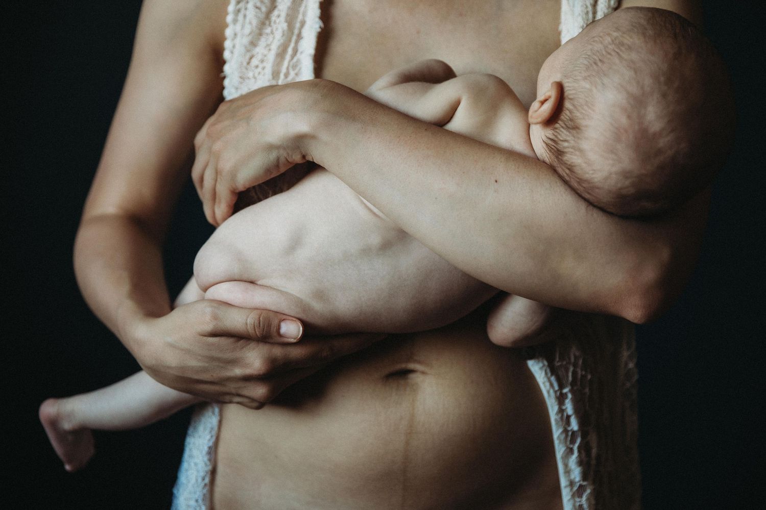 Nude pregnant woman lying on her side looking into camera
