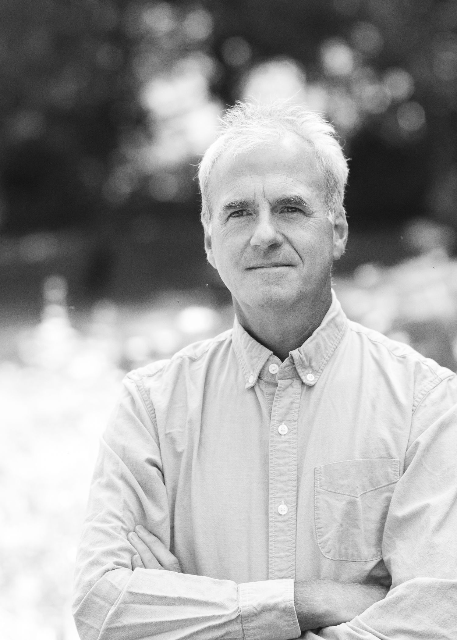 Black and white portrait series showing an elderly person in a white button-down shirt smiling warmly.