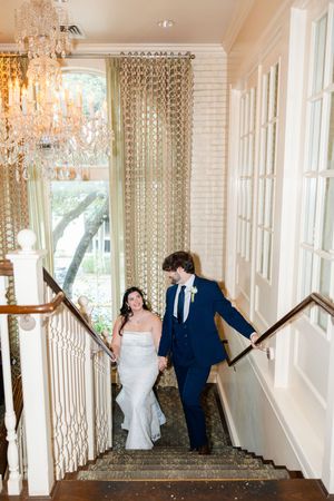 A creative wedding sequence photo showing a couple having fun and interacting along an elegant mirrored hallway with chandeliers.
