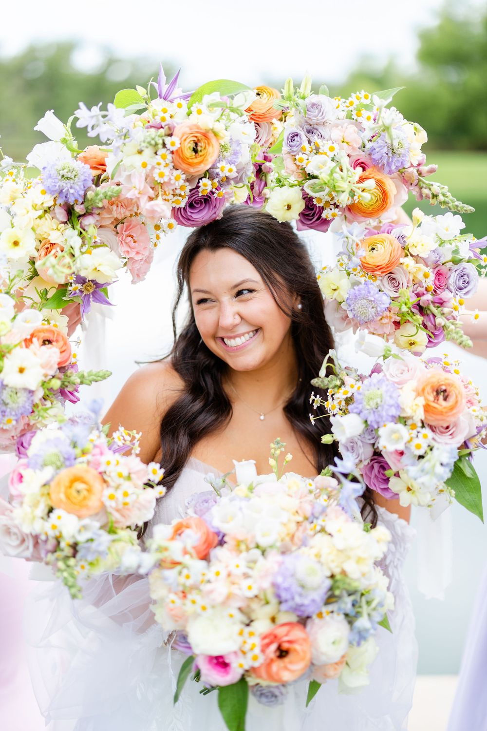 Four beautiful headshots showcase a delicate floral crown made of pastel orange, purple and pink flowers in natural light.
