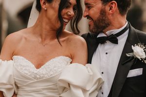 A romantic wedding moment between newlyweds wearing classic black and white formal attire.