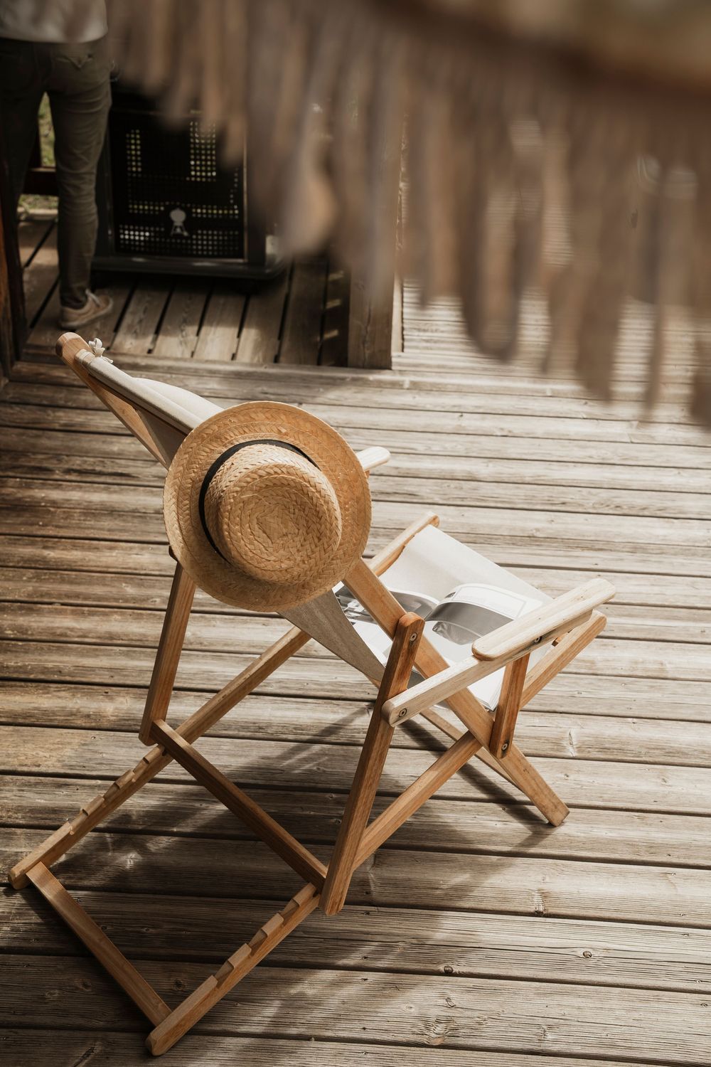 Straw hat resting on a wooden sun lounger on a luxury chalet terrace — alpine outdoor lifestyle detail — Paul Brechu Photography