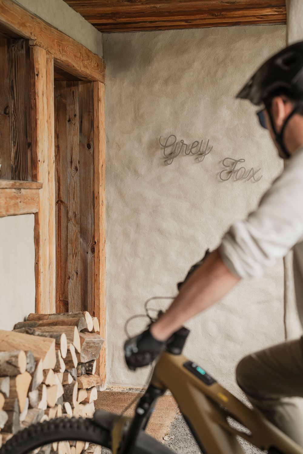 Person at the entrance of a luxury wooden mountain chalet with potted plants — alpine lifestyle photography — Paul Brechu