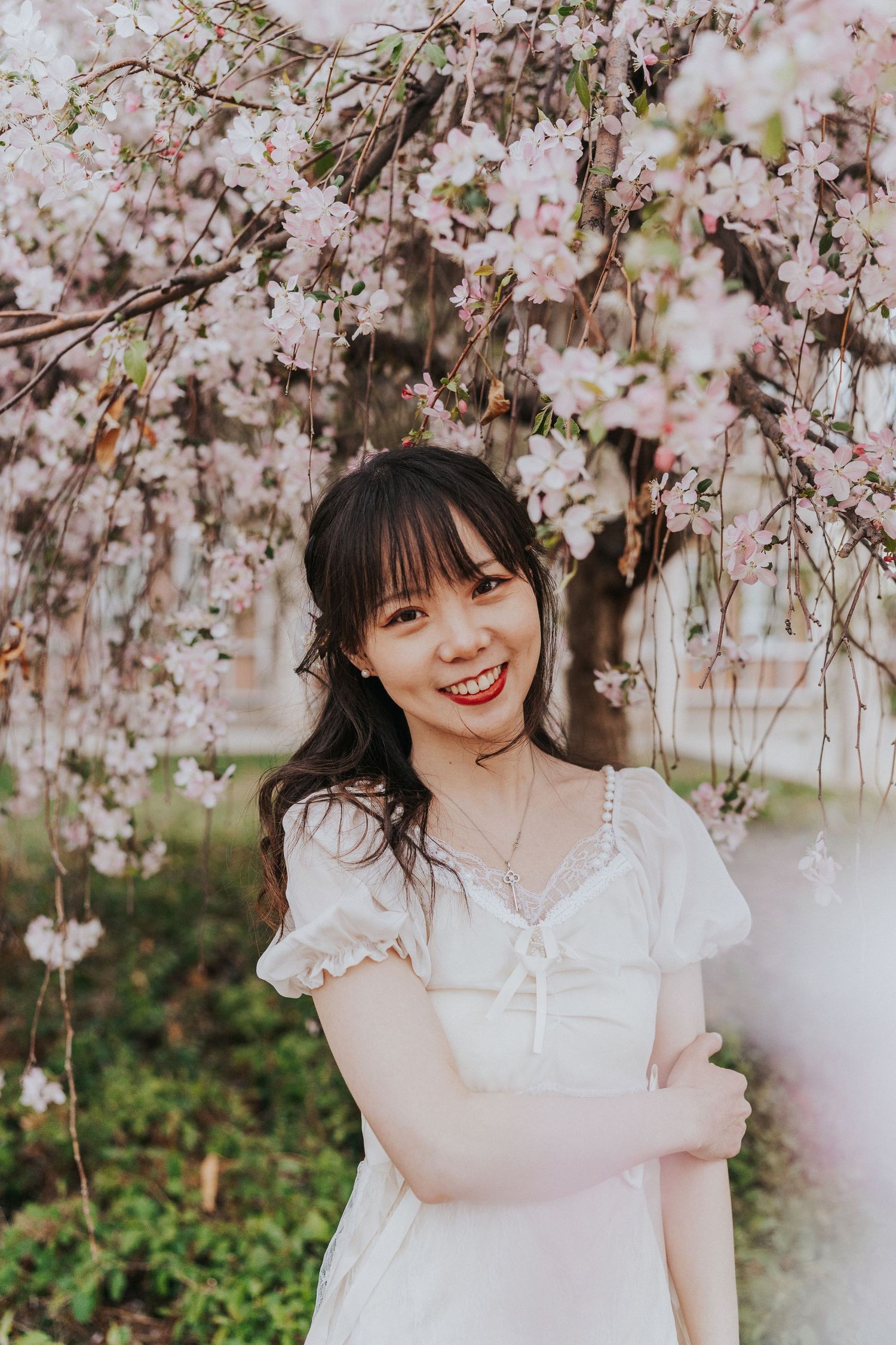 Woman stands amongst cherry blossoms