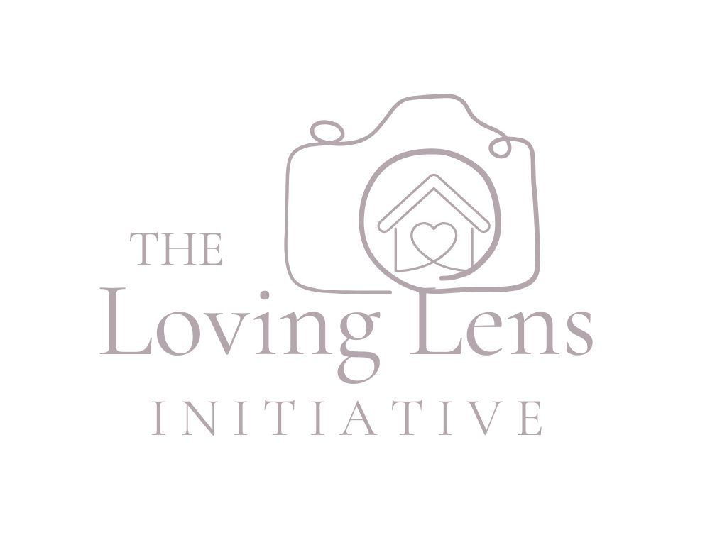 A minimalist logo design featuring a camera icon with a house and heart symbol inside it, titled 'The Loving Lens Initiative'.