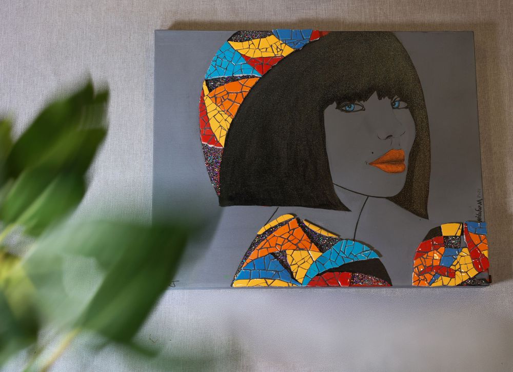 A stylized artwork featuring a geometric bob hairstyle silhouette with colorful mosaic patterns in orange and blue tones.