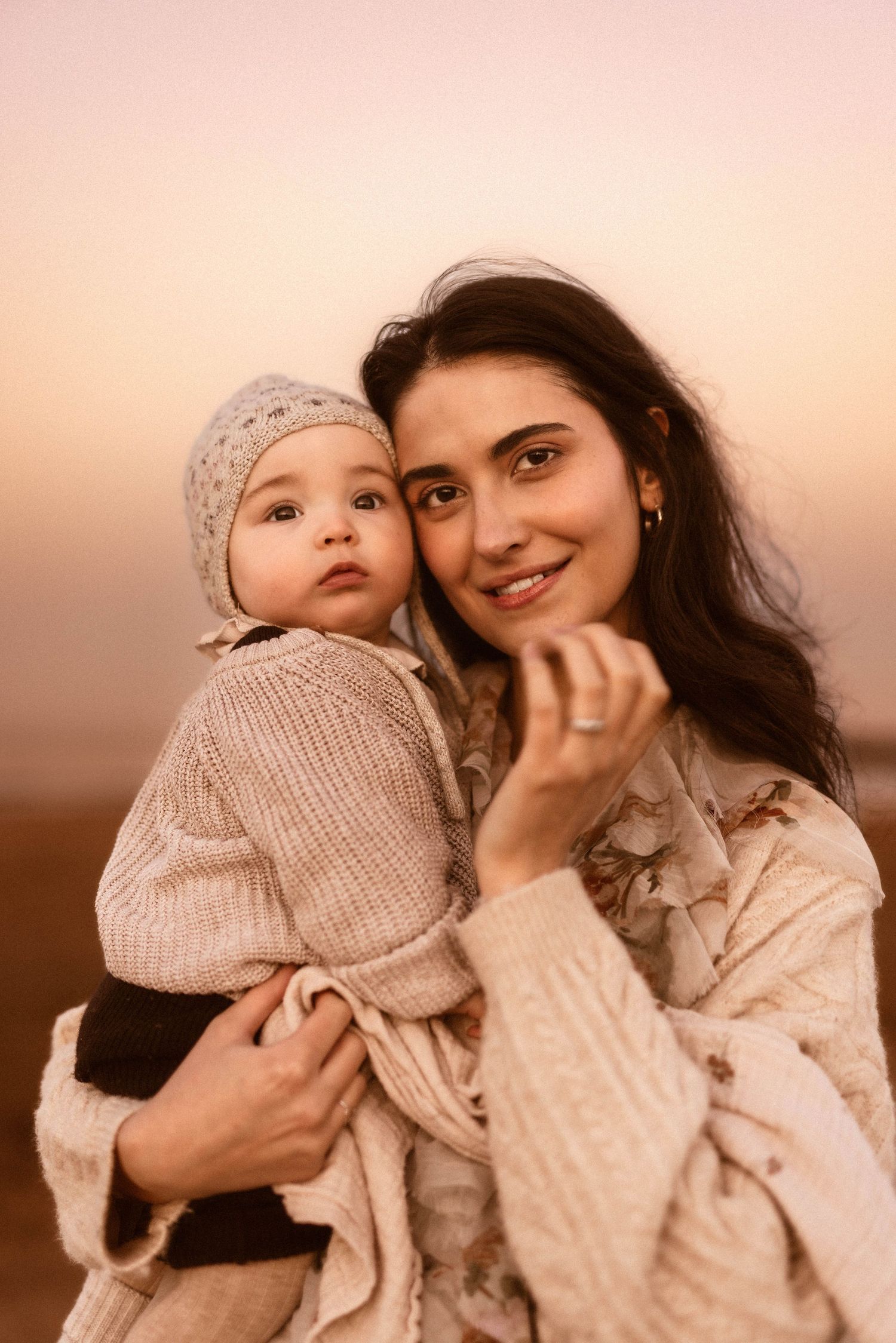 Two people sharing a joyful moment while sitting in a field during golden hour sunset with Javea photographer