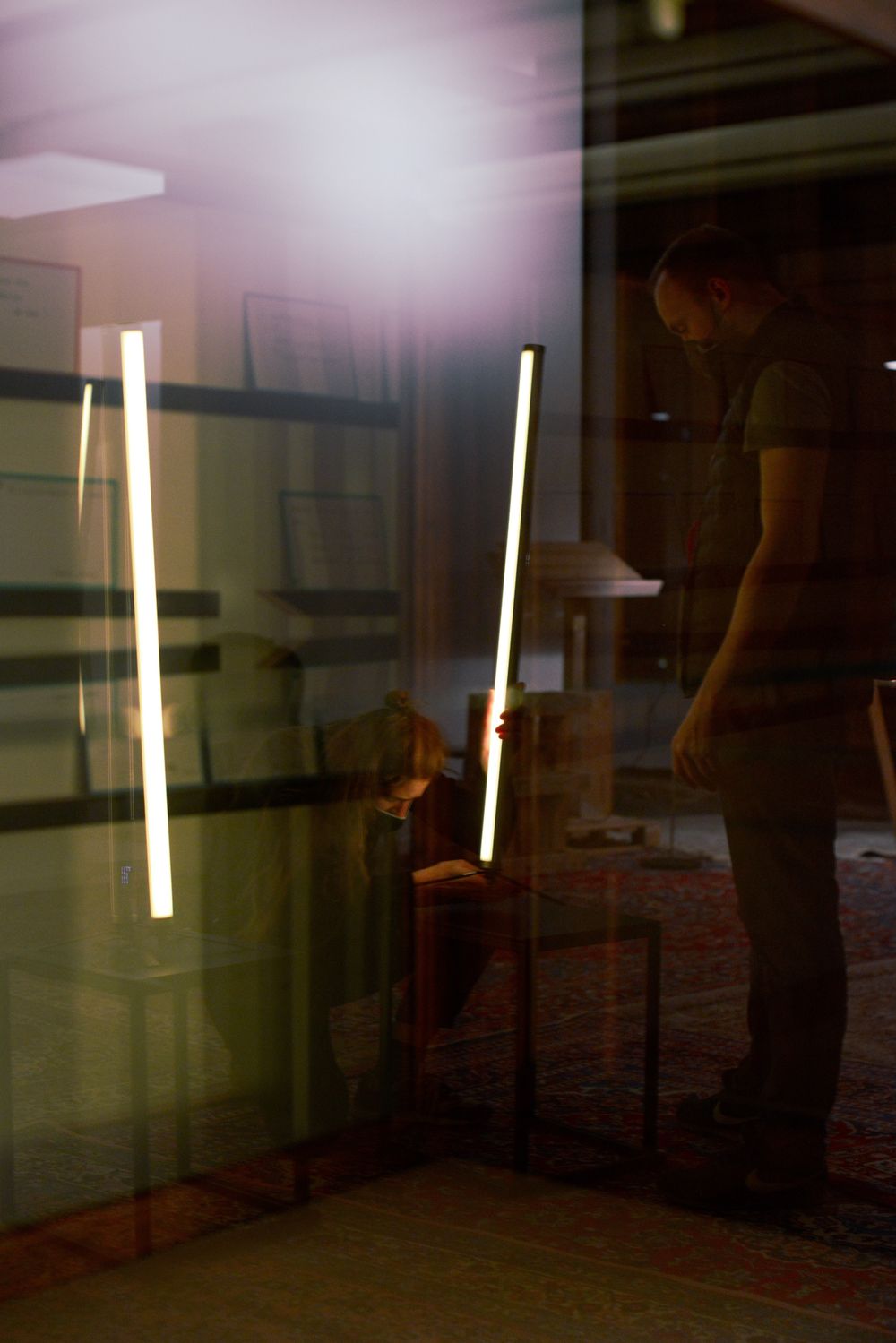 Vertical LED light bars illuminate a dark interior space.