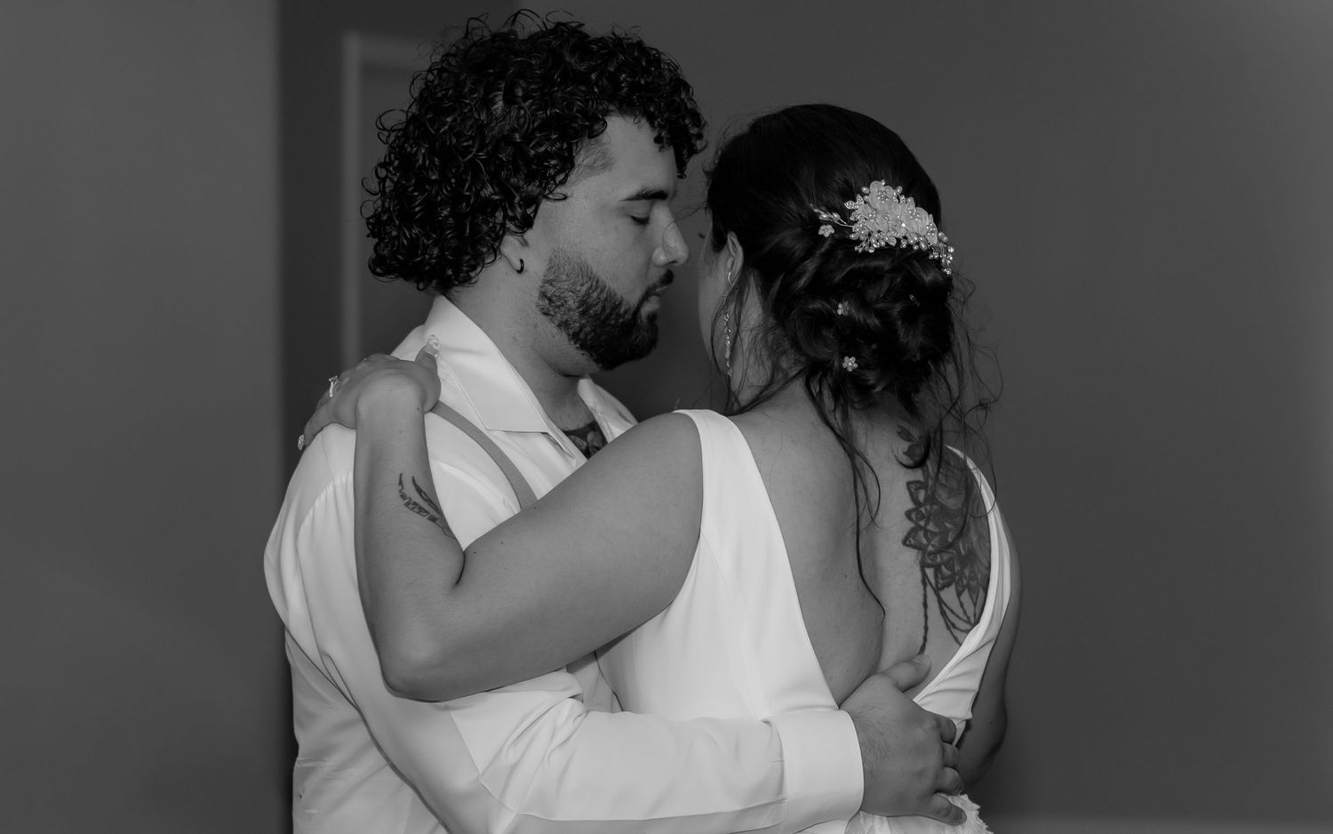 A black and white intimate moment between newlyweds sharing a tender embrace.