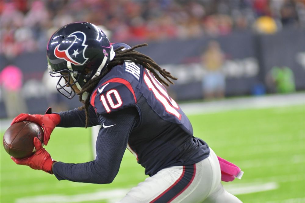 Houston Texans player in navy blue uniform catches football during NFL game.