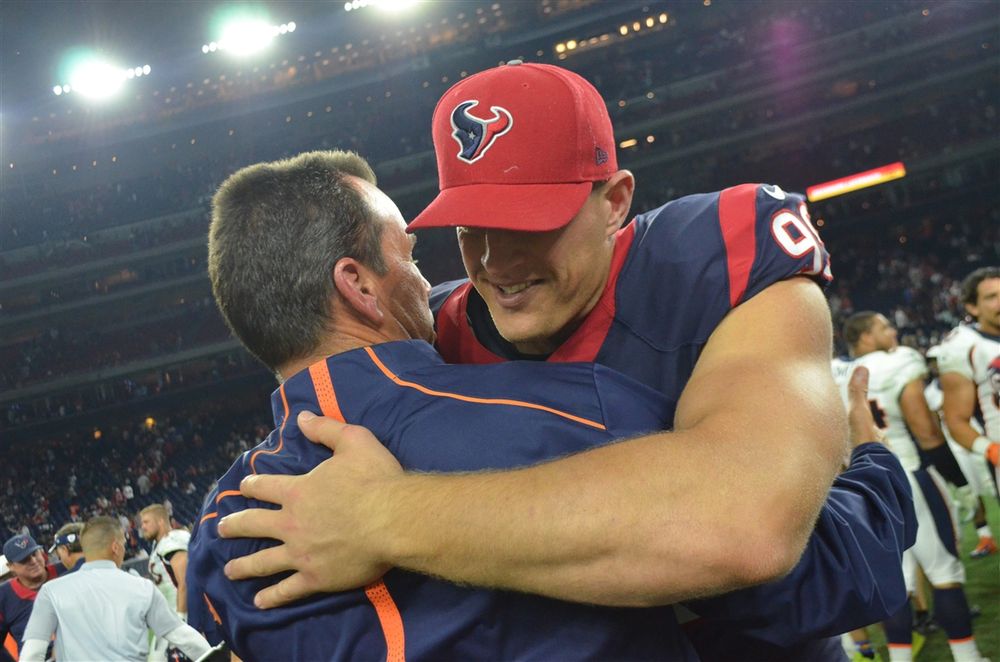 Two members of the Houston Texans embrace in celebration during a game.