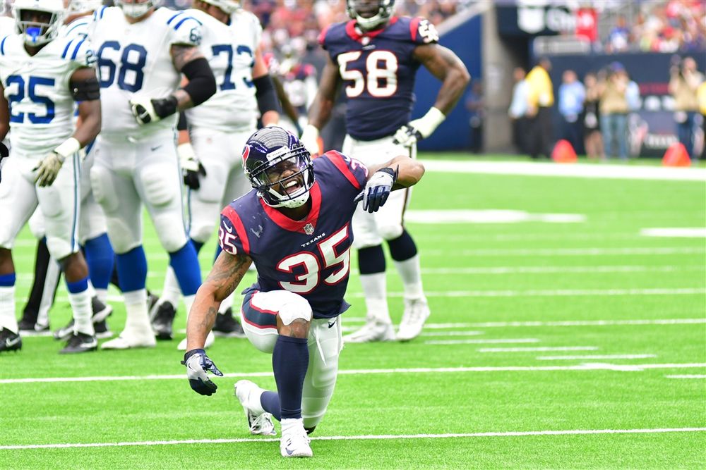 Houston Texans player crouches on the field during an NFL game.