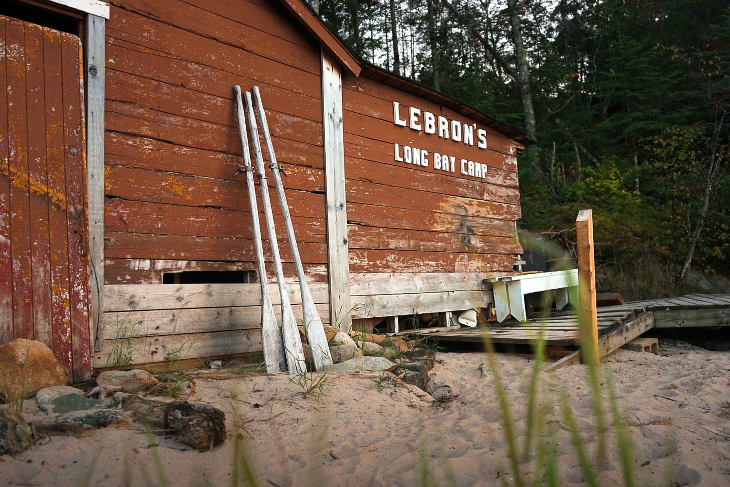 Rustic wooden building exterior with oars mounted on the wall.