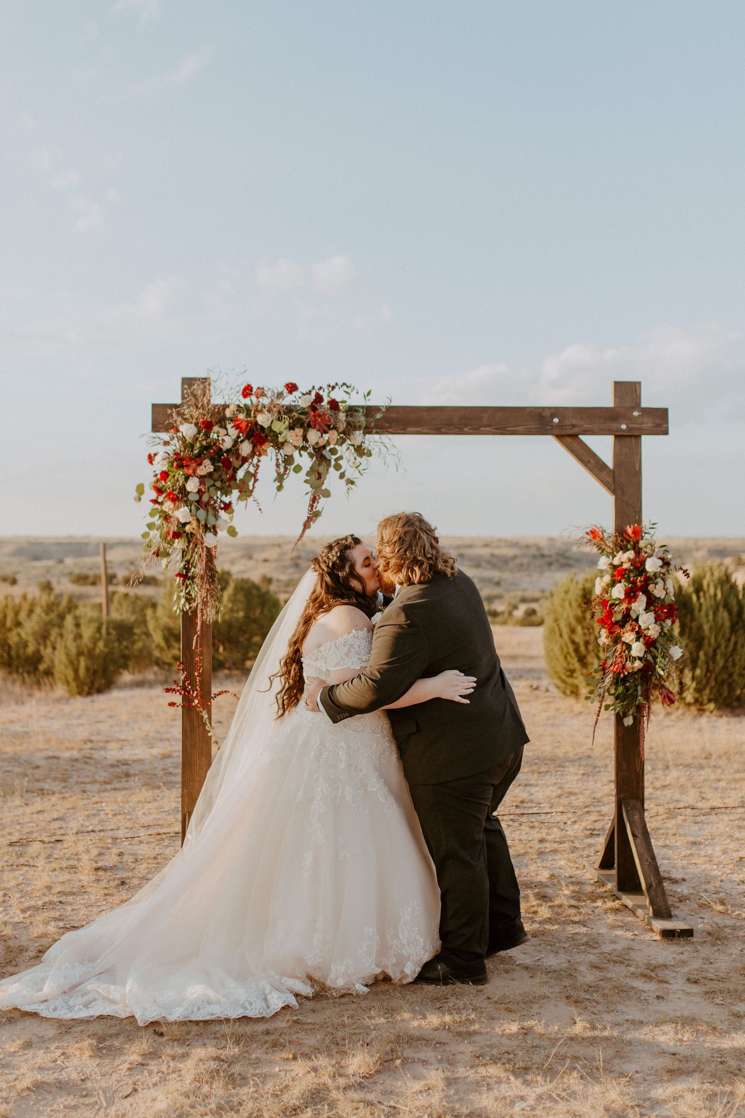 A perfect portrait of a husband and wife kissing on their wedding day at the alter in canyon, tx at sunset.