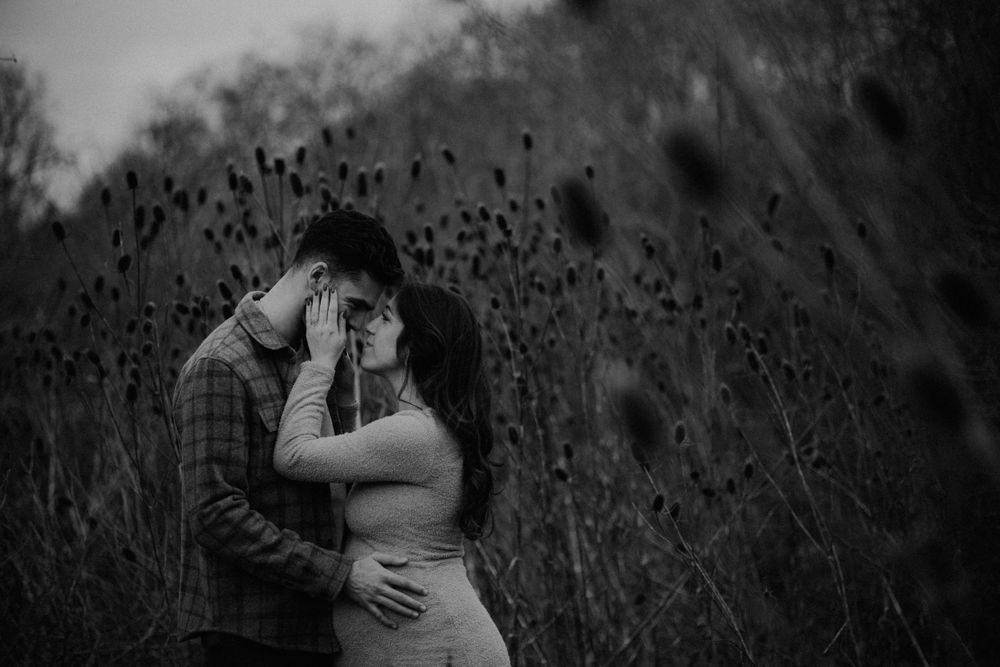 Black and white intimate portrait of couple among wild dried flowers.