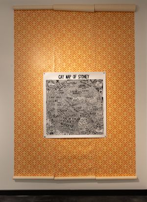 A hand-drawn Gay Map of Sydney displayed on orange patterned wallpaper in a gallery.