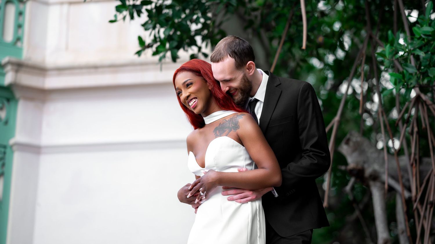 Moments after their Palm Beach estate wedding, the bride and groom take a moment to cuddle and laugh together.