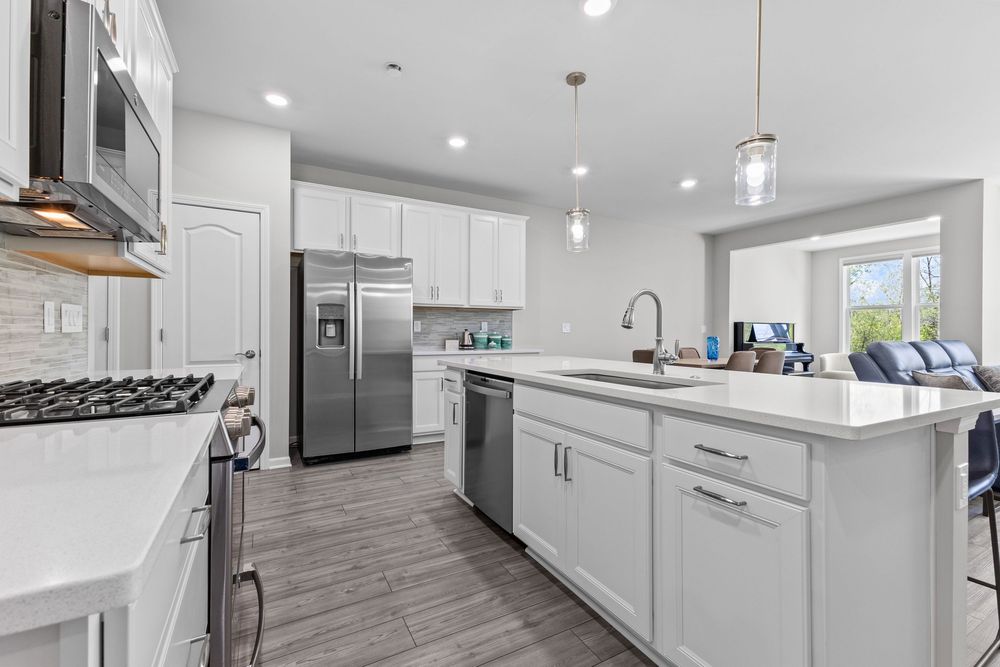 Modern kitchen with white quartz island and stainless appliances in Walled Lake townhome