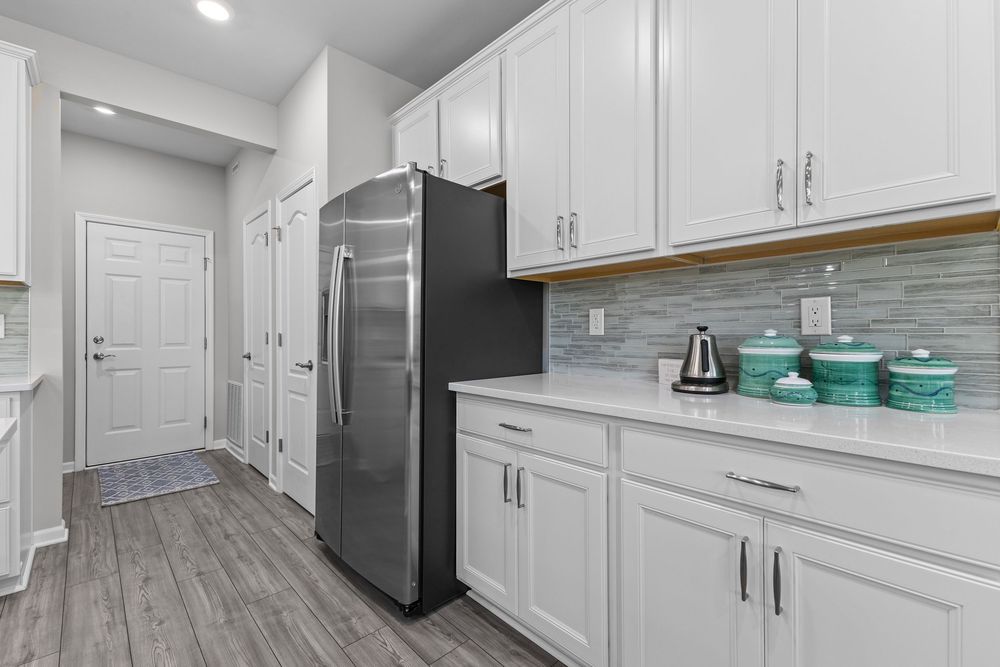 Modern kitchen with white quartz island and stainless appliances in Walled Lake townhome