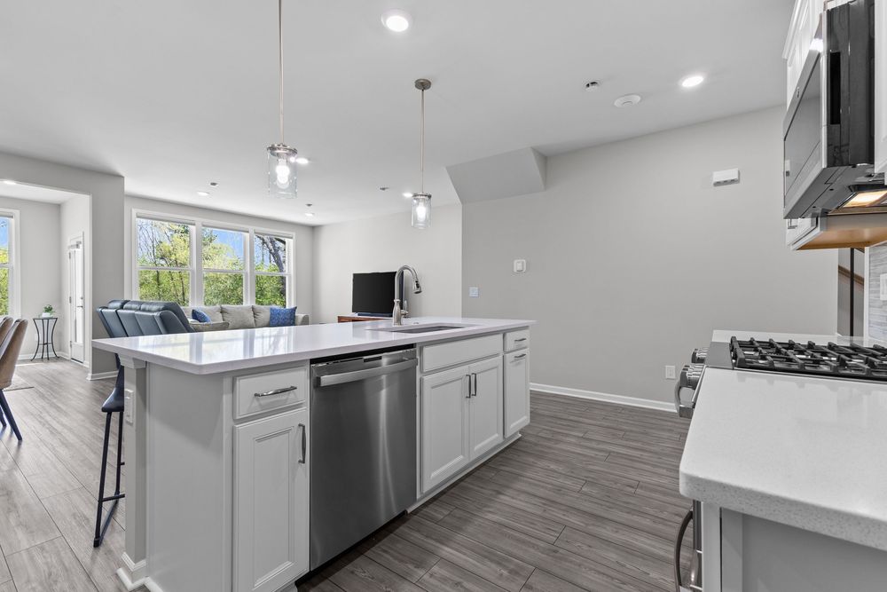 Modern kitchen with white quartz island and stainless appliances in Walled Lake townhome