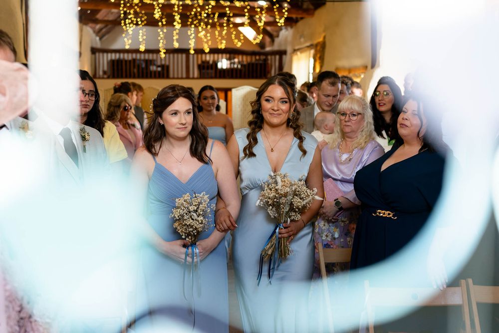 Bridesmaids walking ahead of Bride at Corn Barn Devon Wedding