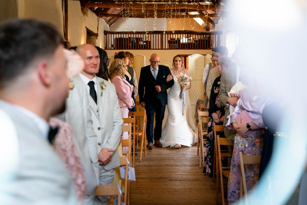 Bride and father walking down isle at the Corn Barn Cullompton