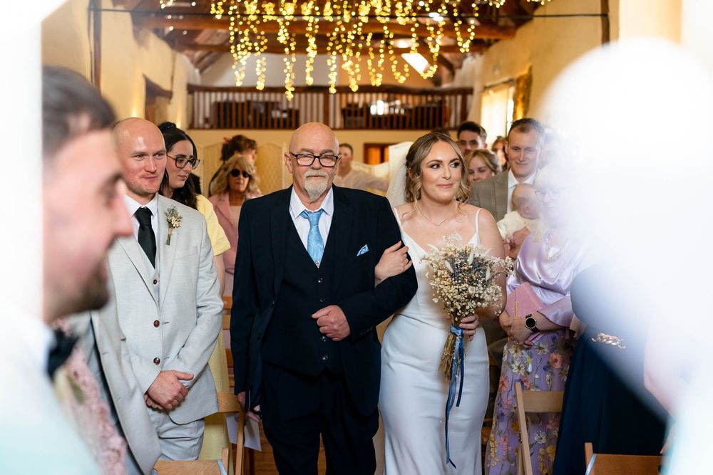 Bride and father walking down isle Devon Wedding Corn Barn