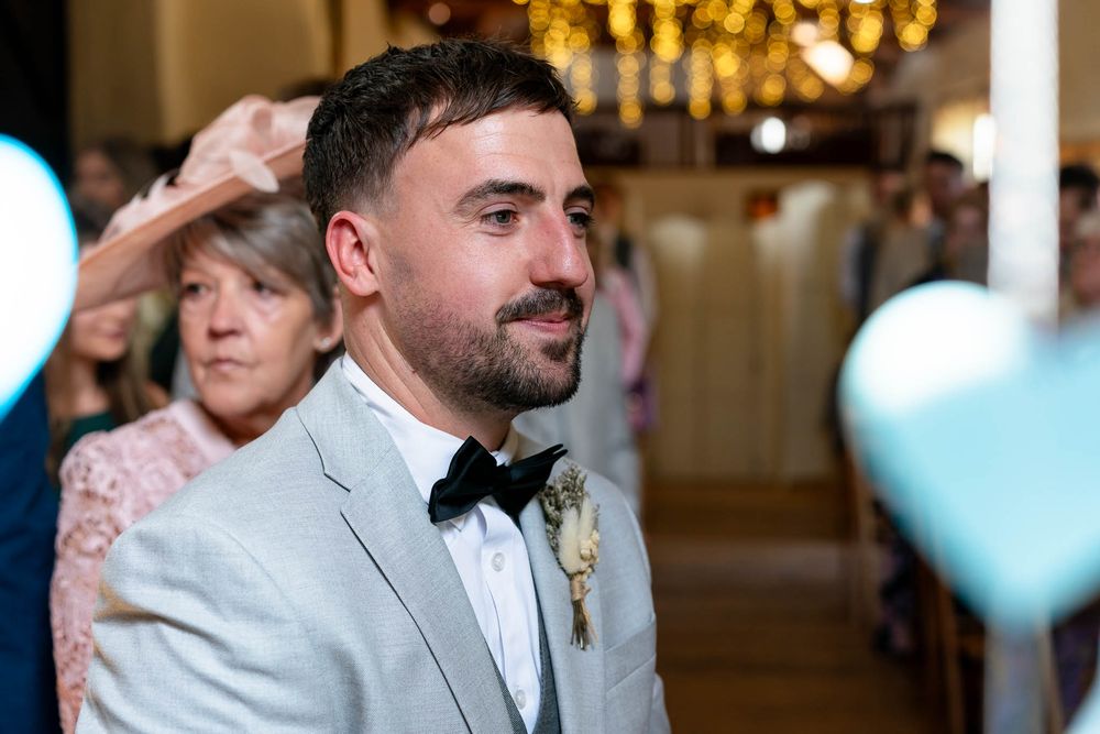 Groom waiting for Bride to arrive down isle at Corn Barn Devon Wedding