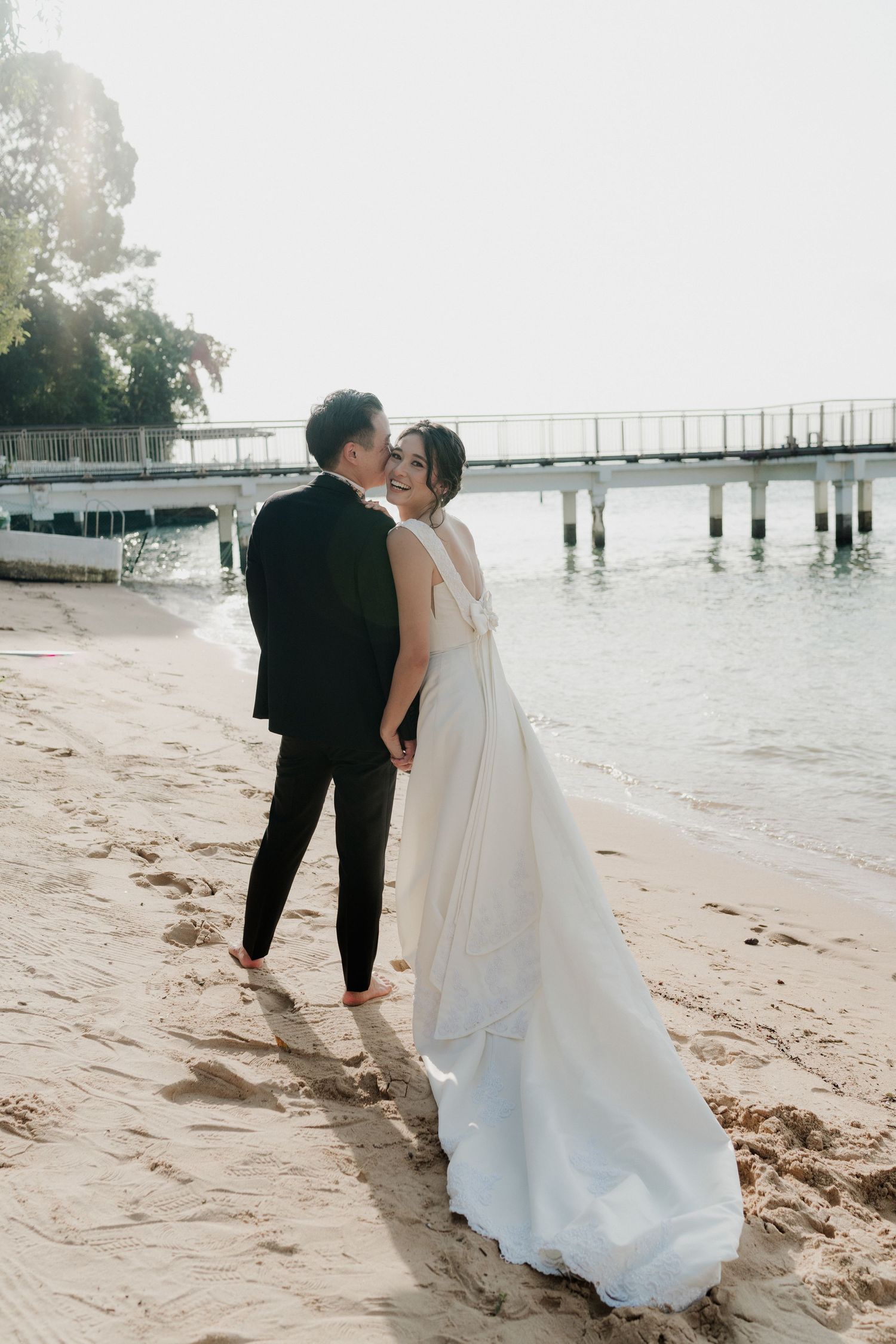 A creative wedding photoshoot under white arches with couples lying on the floor.