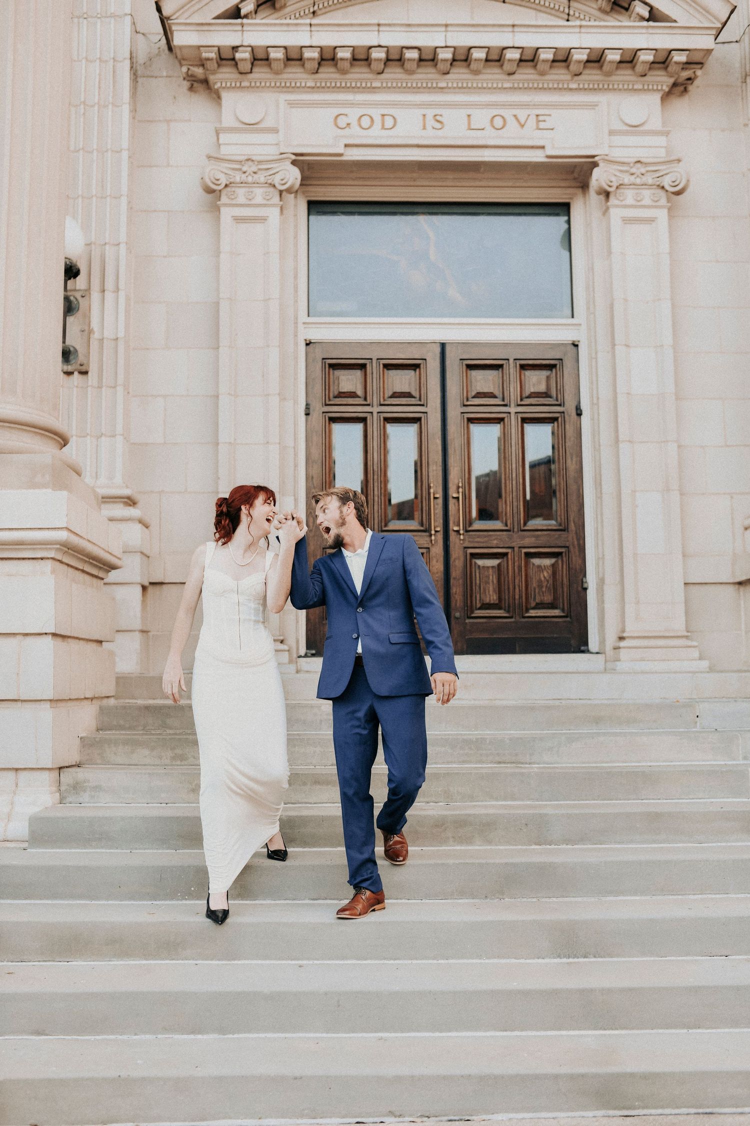 Couple sharing candid laughter in front of historic Dallas architecture