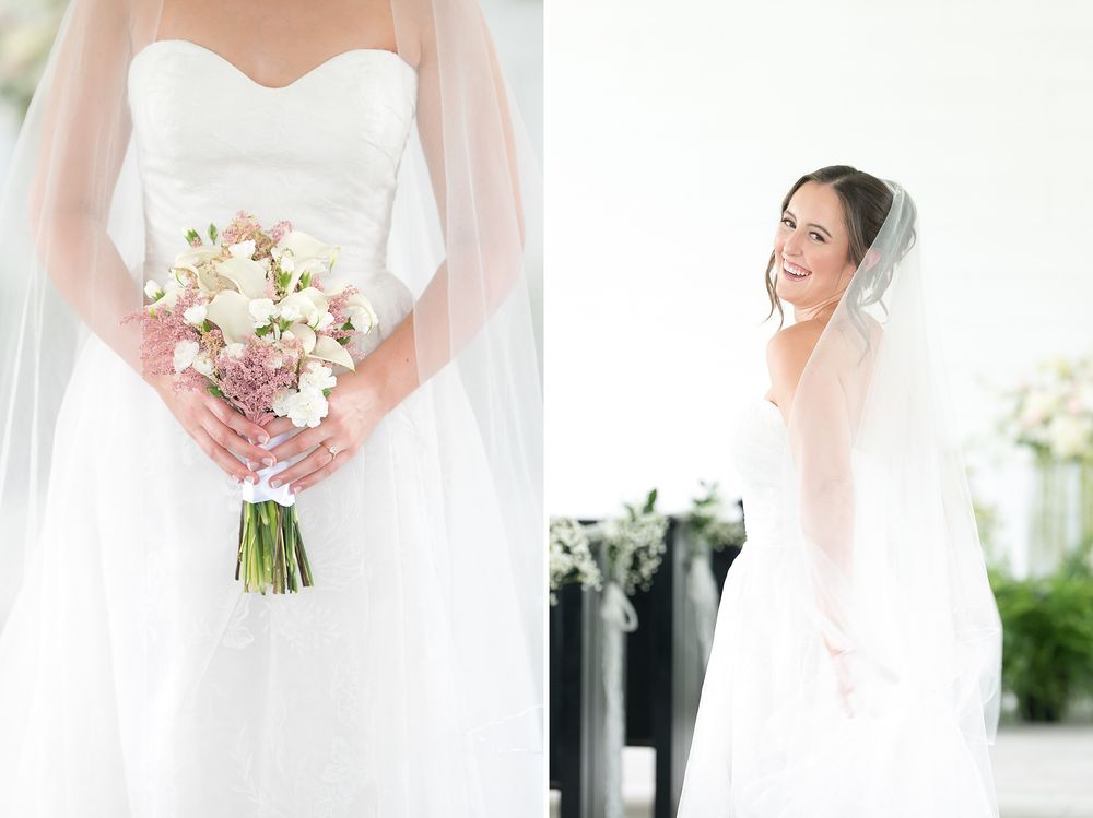 Smiling bride in strapless white gown and veil holds a pink and white floral bouquet.