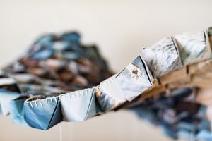 Close-up of colorful origami paper garland with blue and brown patterned folded shapes linked together.