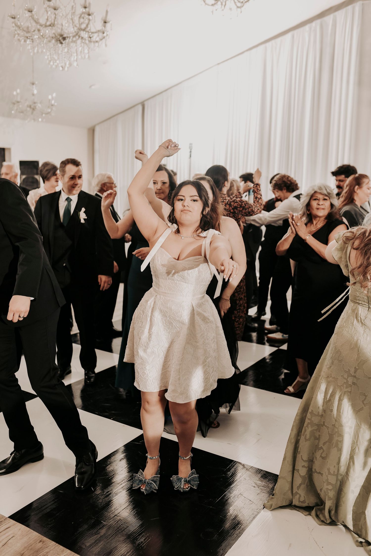 Newlyweds sharing their first dance on a checkered dance floor