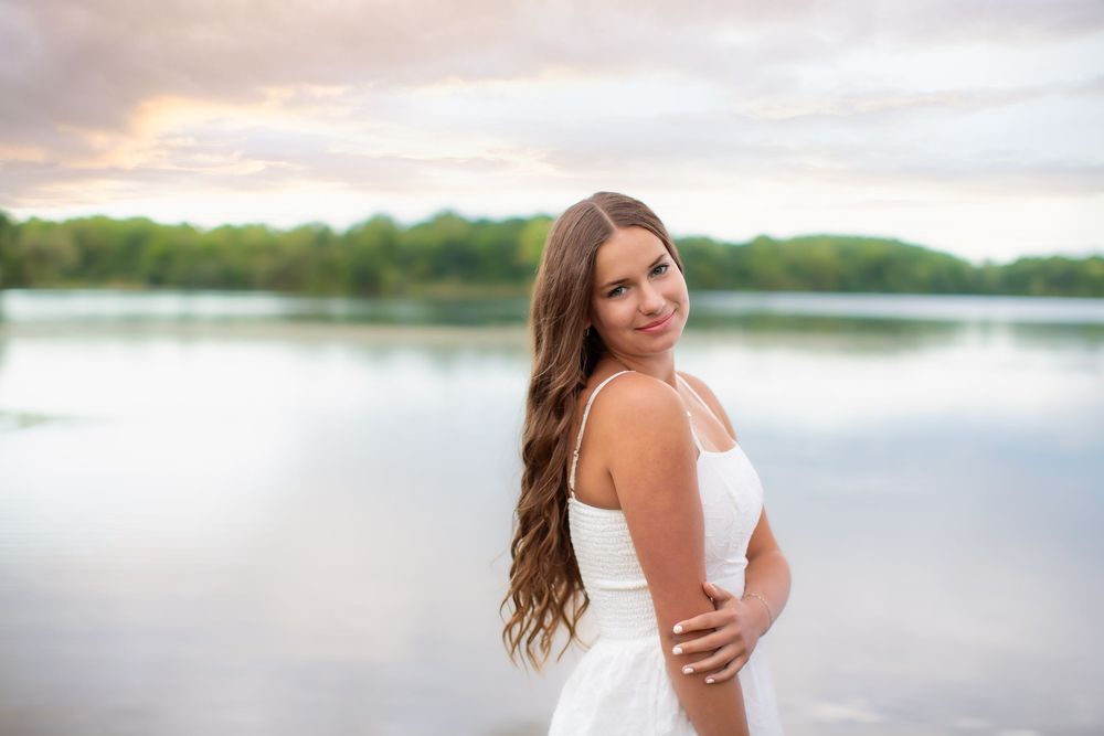 Senior sunset editorial portrait at Island Lake, Brighton Michigan; girl standing in lake with cinematic vibe by South Lyon, MI photographer