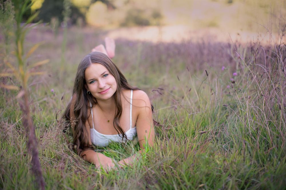 Senior portrait at Island Lake, Brighton Michigan; girl in flower field with cinematic vibes by South Lyon, MI photographer