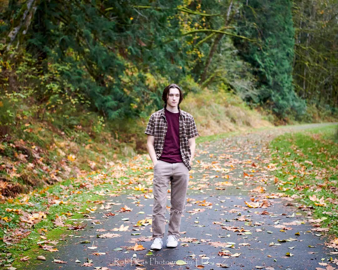 High school senior male at Snoqualmie-Preston trail standing on old rail line.