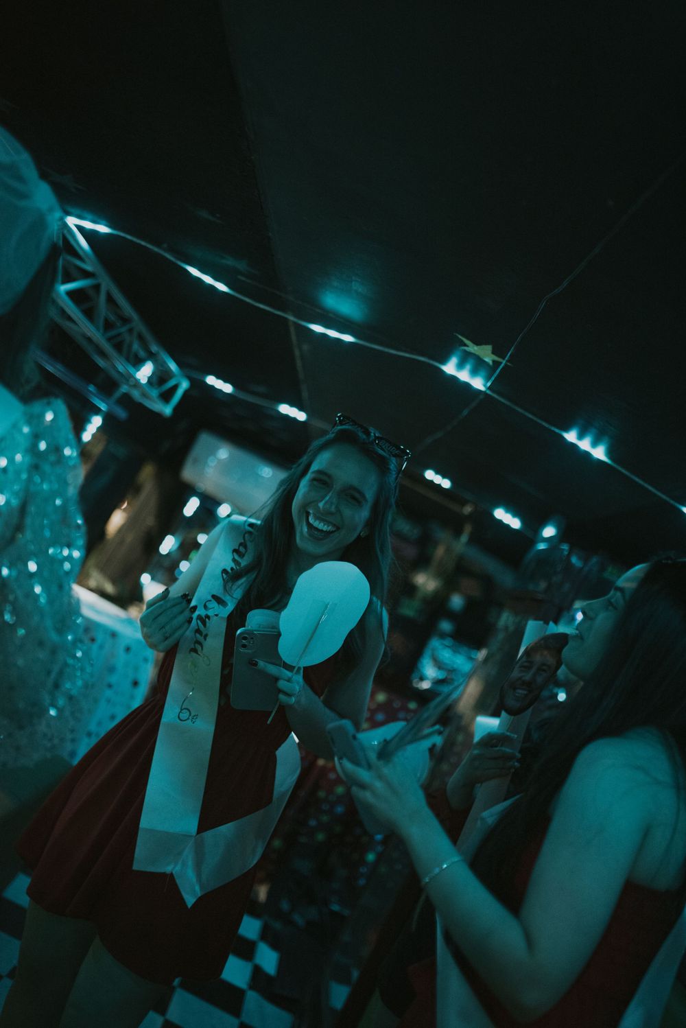 Celebration scene in blue-tinted lighting with party-goers enjoying the festivities.