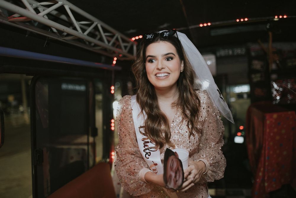Person in a sparkly dress and bridal veil poses during a celebration.