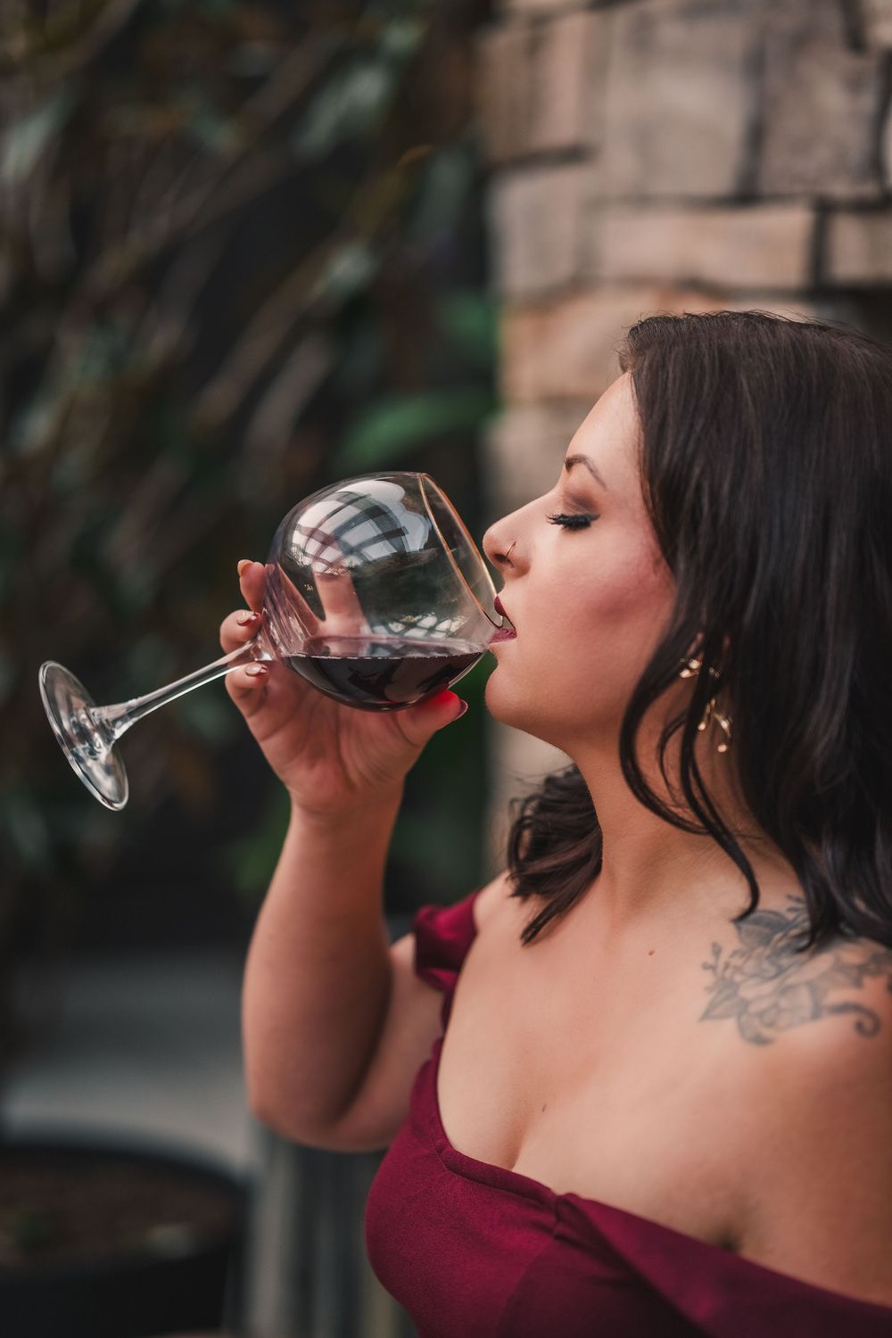 Woman in burgundy dress drinking red wine from glass, shown in multiple sequential profile shots.