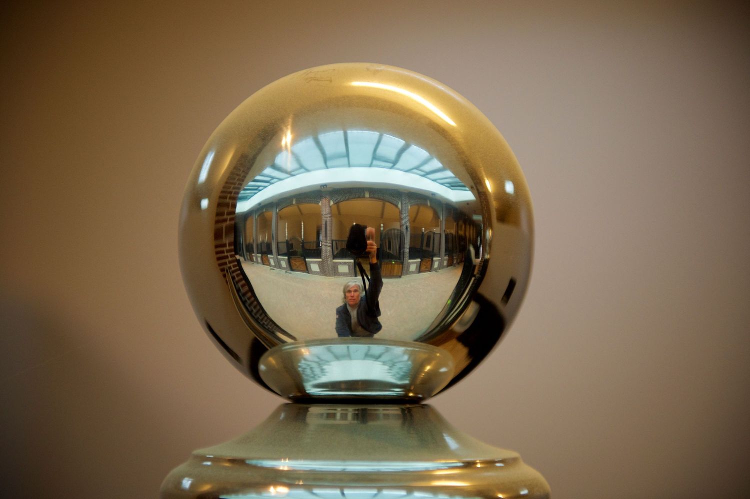 Crystal ball reflects an ornate interior space with distorted architectural details.