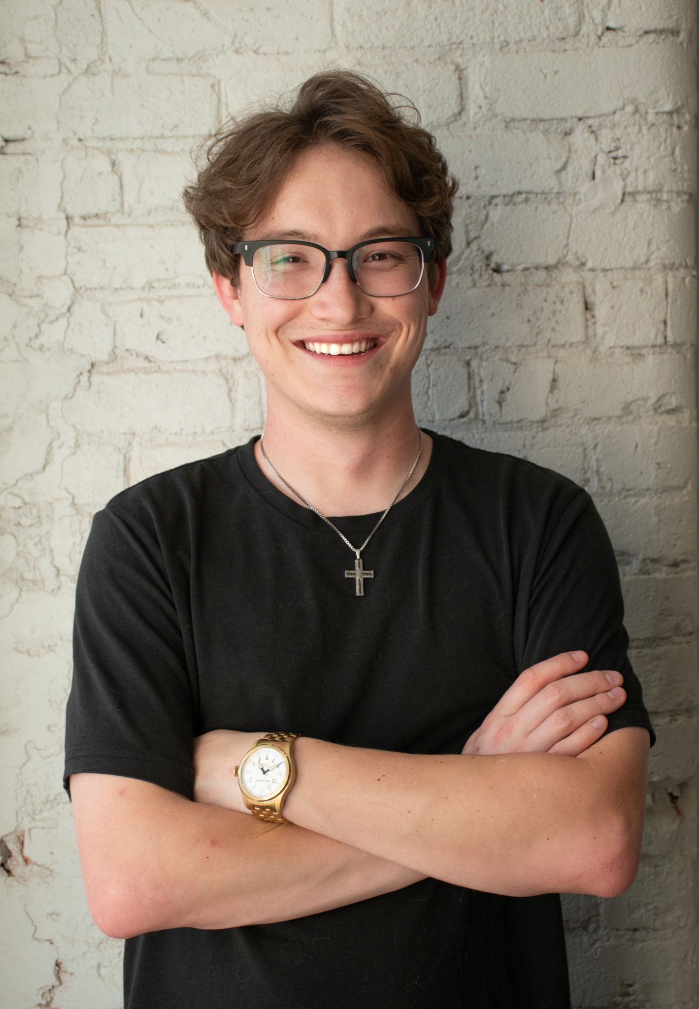 Person wearing black shirt and glasses in front of white brick wall shows progression of poses.