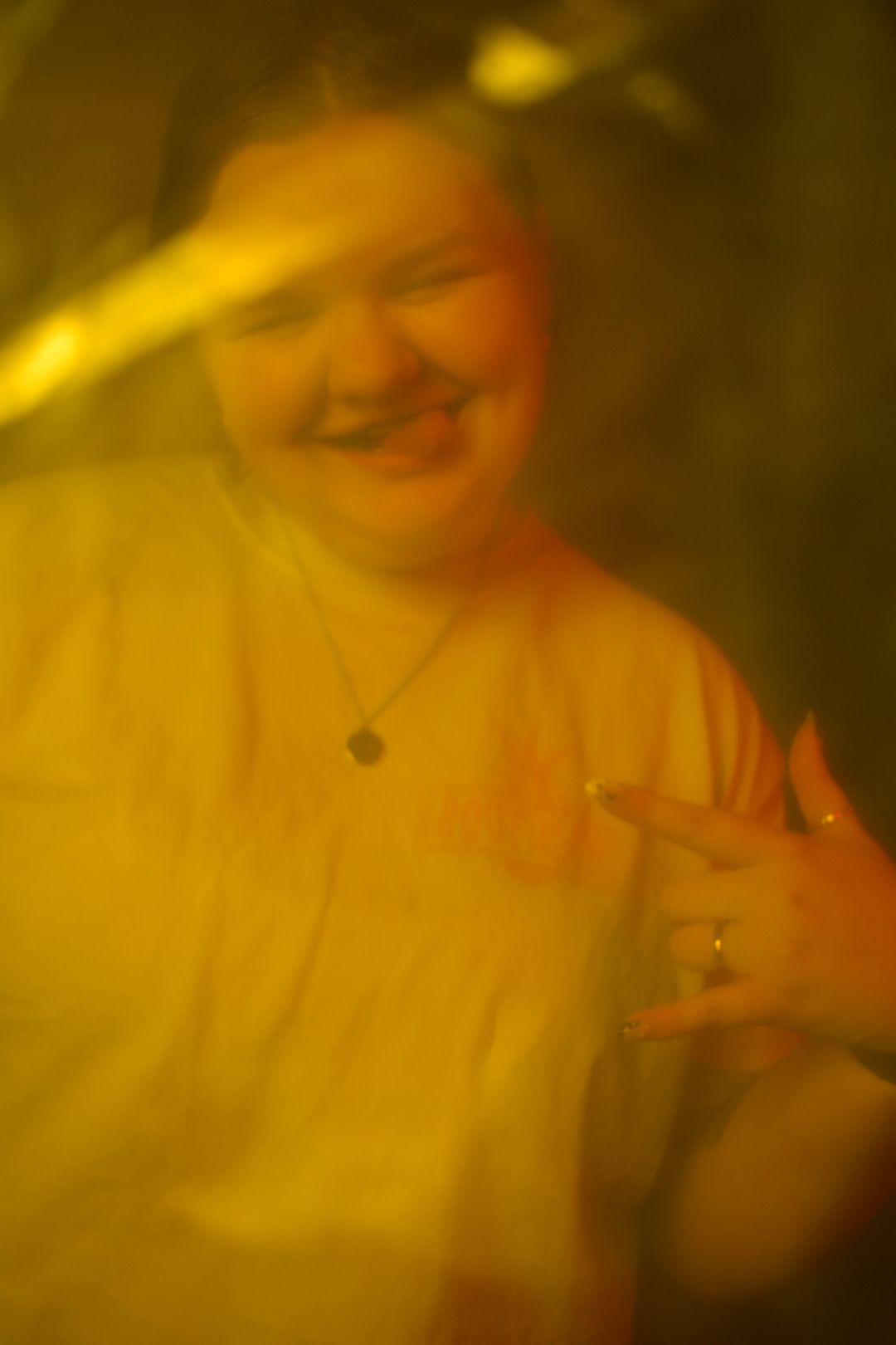 Portrait featuring a warm yellow glow and soft smile in casual attire.