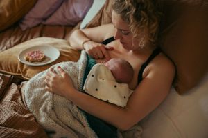moeder en dochter op bed met beschuit met muisjes