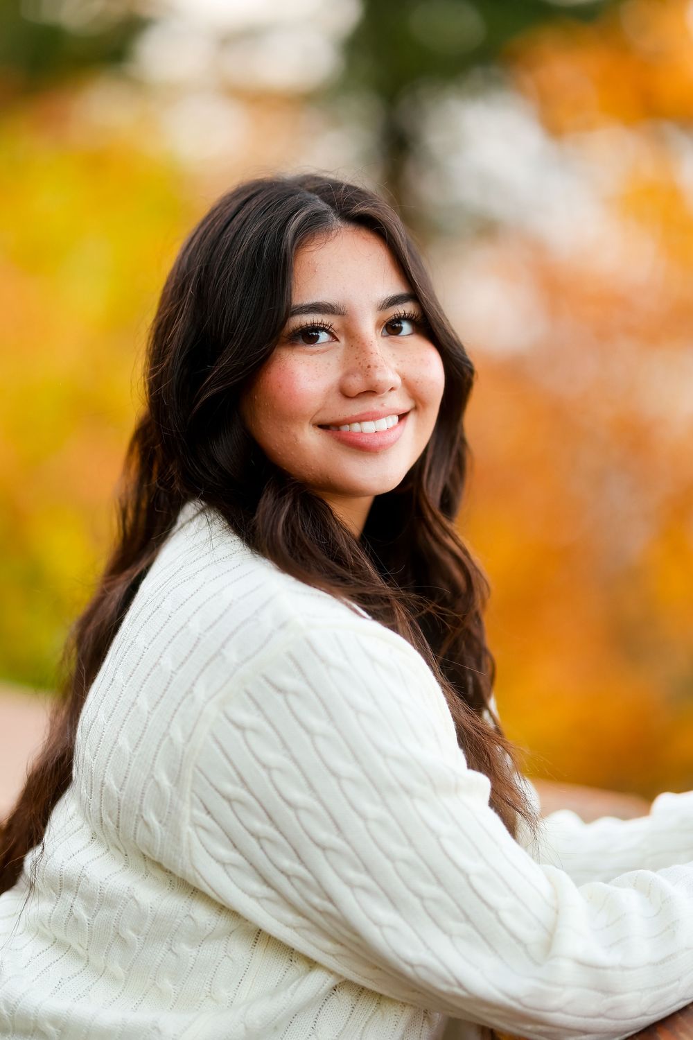 Close-up portrait with warm fall colors and a cable knit cream sweater.