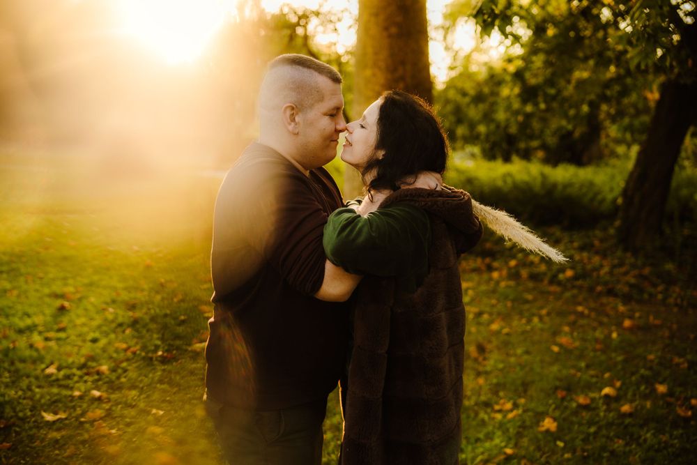 A tender embrace captured during golden hour in an autumn garden.