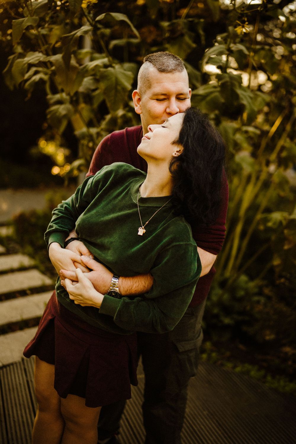 Romantic autumn portrait of couple embracing in garden setting.