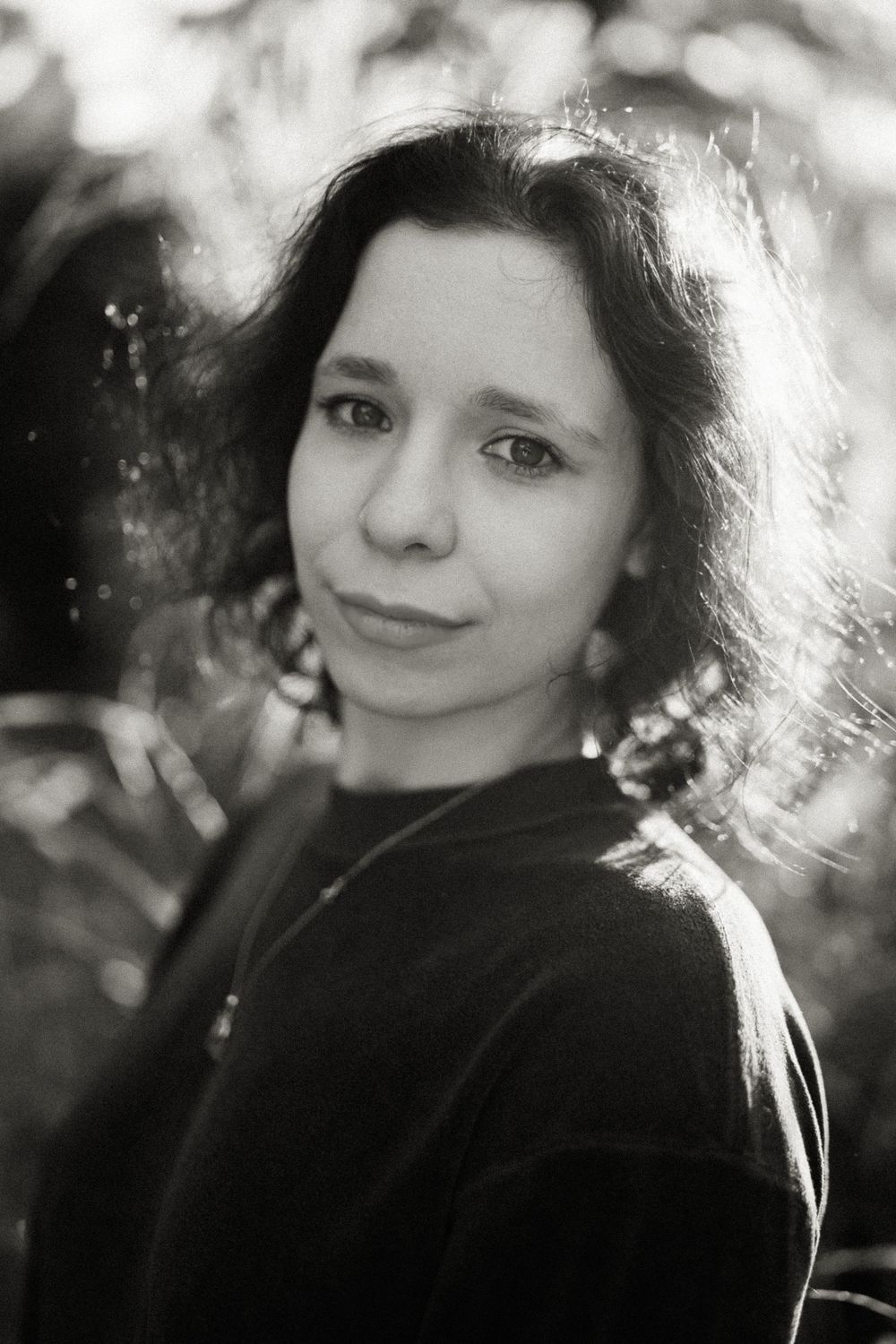 Portrait photo with dreamy backlighting and soft bokeh effect creating an ethereal atmosphere.