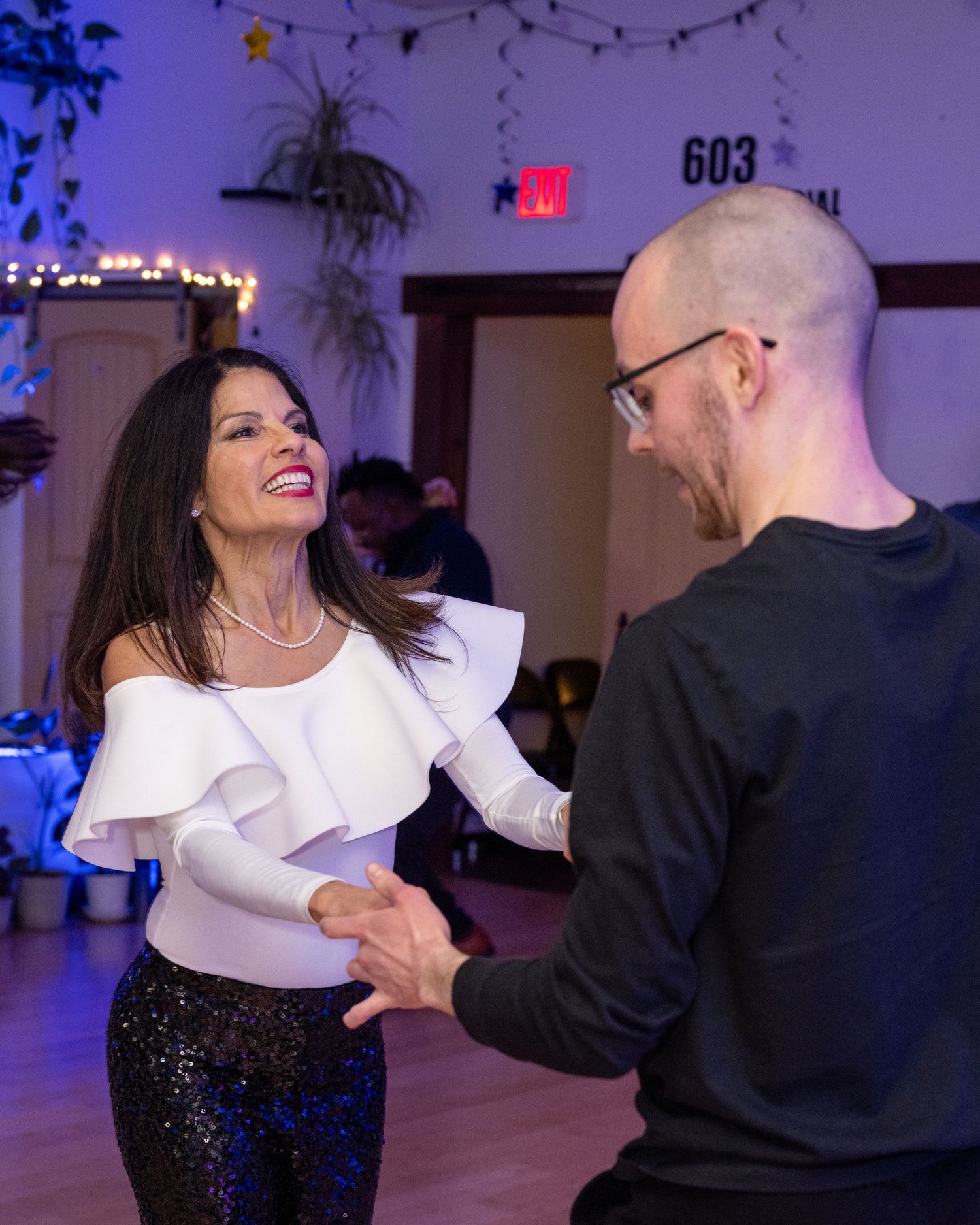 Woman dancing with man at dance event. They look naturally happy in the candid photo, their chests held high with confidence.